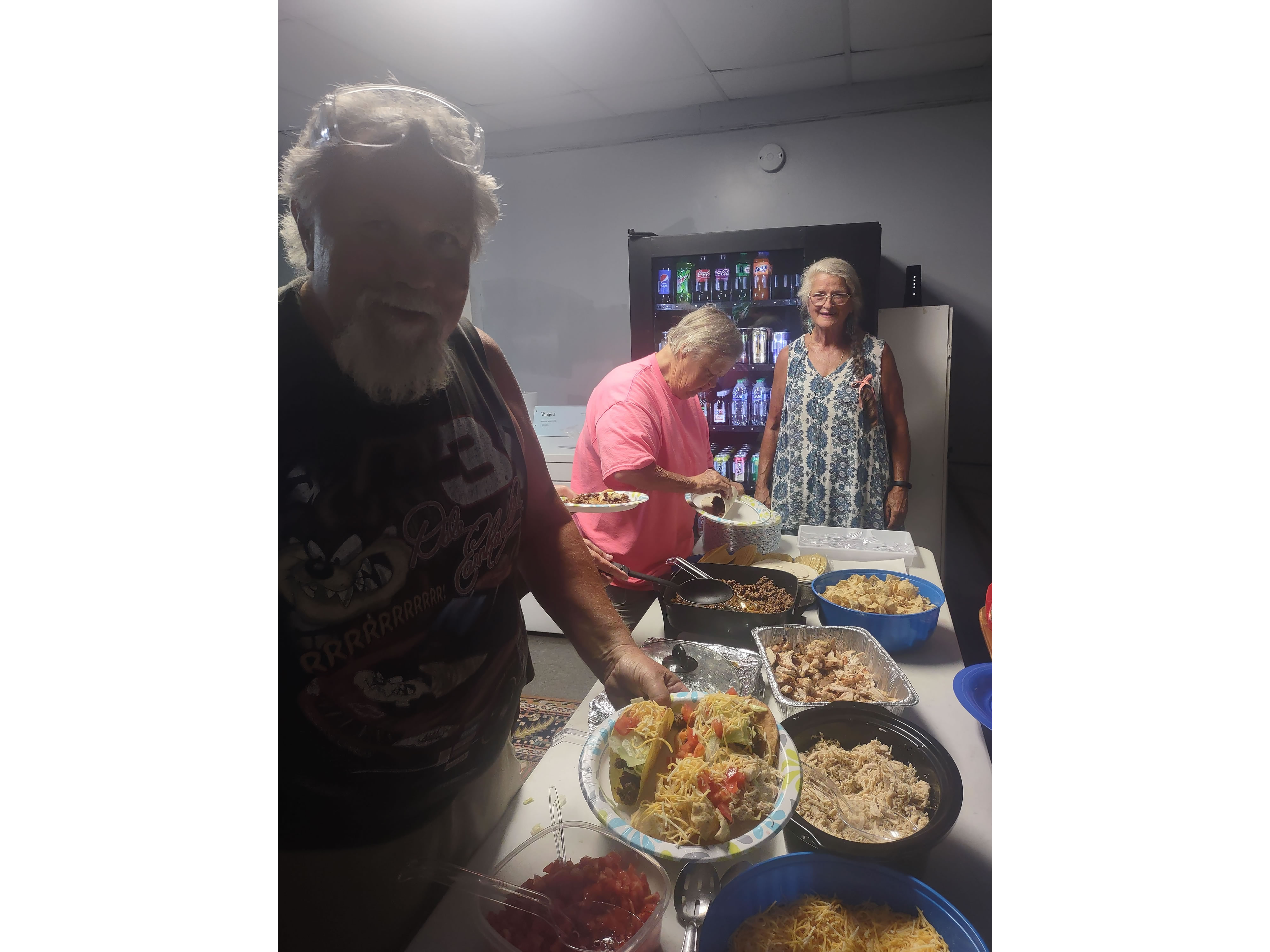 Rich, Ginnie, and Ernette getting building their plates at the taco bar